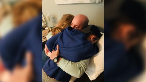 Hurley's husband is hugged by his two children after spending five days in the hospital with Covid-19.