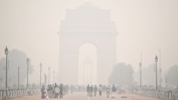 TOPSHOT - People walk along Rajpath near India Gate under heavy smog conditions in New Delhi on November 9, 2020. (Photo by Sajjad HUSSAIN / AFP) (Photo by SAJJAD HUSSAIN/AFP via Getty Images)