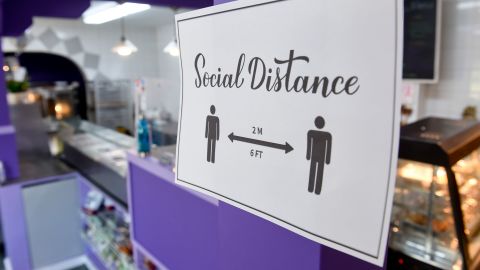 At Marisol's Bakery and Cafe in Pennsylvania, a sign asks people to social distance on October 6, 2020. Some Americans view returning to life as normal now as a moderate-level risk, a new poll has found.