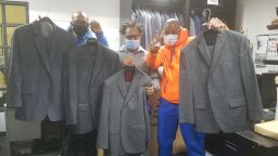 Trainees from The Doe Fund's "Ready, Willing & Able" program, (r-l) Michael Smith, Joseph Calhoun and George Thomas, receive the donated wardrobe.