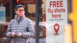NEW YORK, NEW YORK - DECEMBER 01: A person stands by a sign advertising flu shots at CVS as the city continues the re-opening efforts following restrictions imposed to slow the spread of coronavirus on December 01, 2020 in New York City. The pandemic has caused long-term repercussions throughout the tourism and entertainment industries, including temporary and permanent closures of historic and iconic venues, costing the city and businesses billions in revenue. (Photo by Noam Galai/Getty Images)
