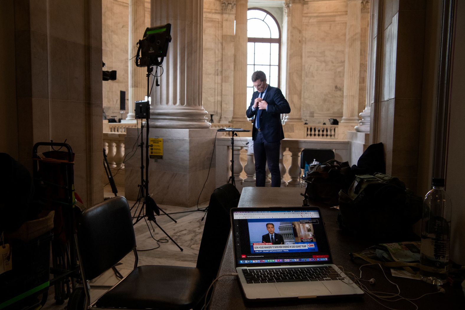 A laptop plays coverage of the trial while a TV crew works from the Capitol Rotunda on Wednesday.