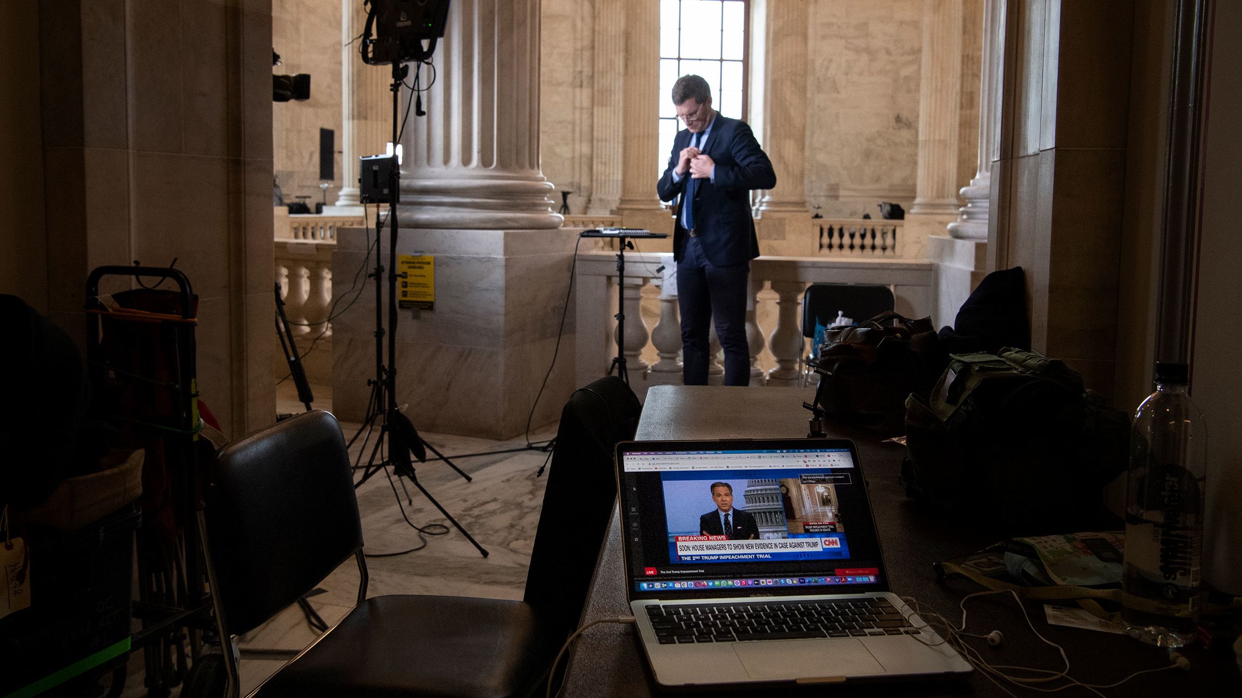 A laptop plays coverage of the trial while a TV crew works from the Capitol Rotunda on Wednesday.