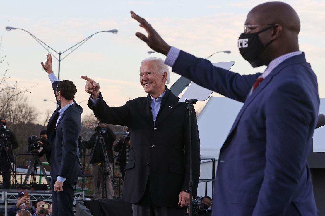 Biden rallies with Democratic candidates for the U.S. Senate Jon Ossoff (L) and Rev. Raphael Warnock (R) the day before their runoff election January 4, 2021 in Atlanta, Georgia.