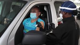 Armando Bravo receives a Covid-19 vaccine from a health care worker at a drive-thru site January 13 in Miami.