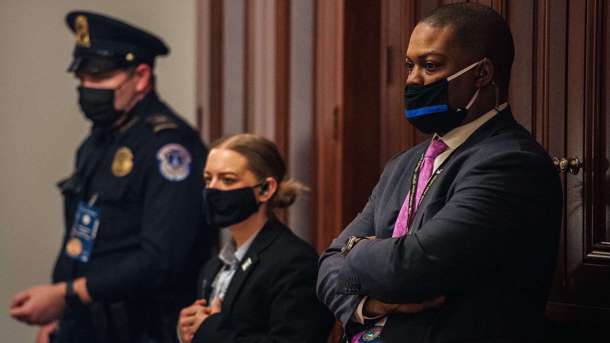 Capitol Police Officer Eugene Goodman, right, watches video footage of the Capitol riot on Wednesday. The security video, which the House impeachment managers played for the first time Wednesday, shows Goodman <a href="https://www.cnn.com/2021/02/10/politics/eugene-goodman-us-capitol-riot/index.html" target="_blank">potentially saving Sen. Mitt Romney</a> from the violent mob.