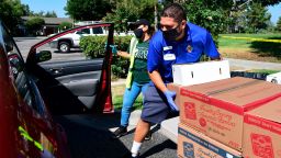Volunteers help load boxes of food into vehicles at a food bank in the Los Angeles County city of Duarte, California on July 8, 2020 as the record for most coronavirus cases in a single day is set in California.