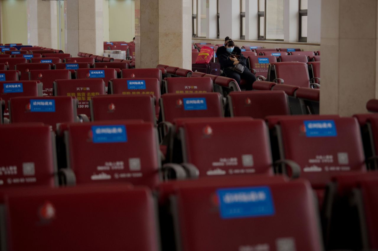 A passenger sits on a bench at a Beijing railway station on February 11. Because of the pandemic, fewer people are traveling home for the holiday.