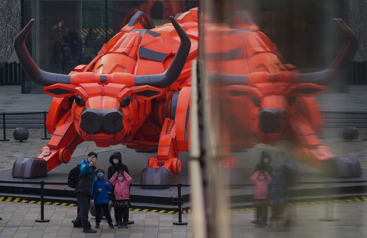 A family takes a picture in front of an ox sculpture at a mall in Beijing on February 11.
