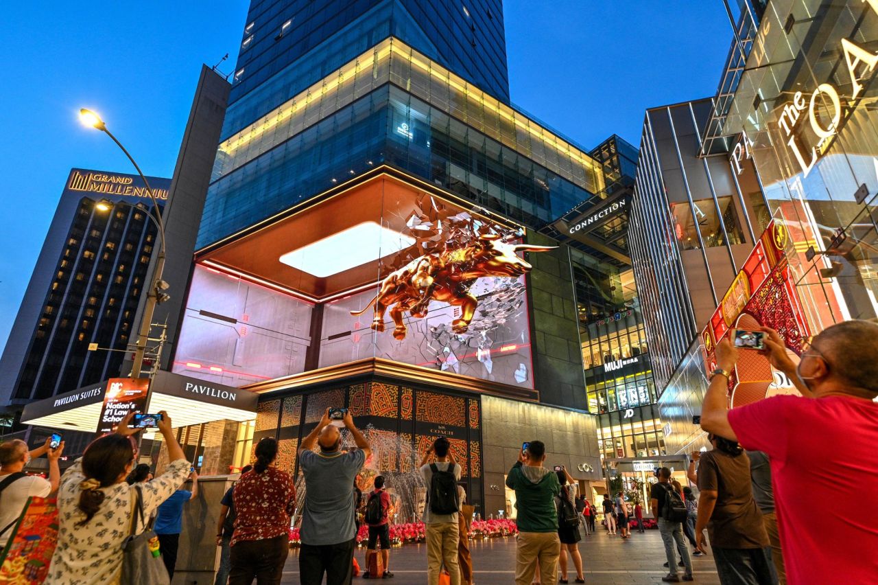People take photos and videos of a 3-D display outside a mall in Kuala Lumpur, Malaysia.