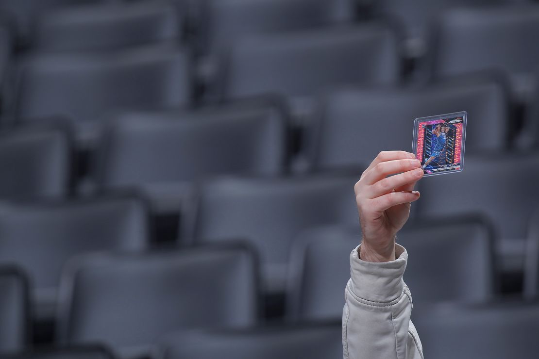 A fan holds up trading cards of Minnesota Timberwolves players prior to a game on Feb. 3, 2020.