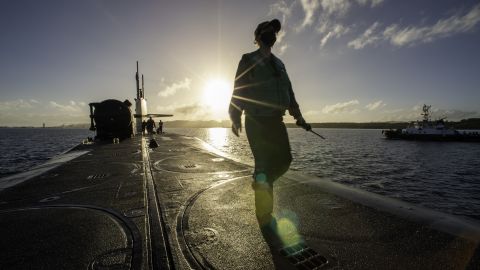 A sailor assigned to the guided-missile submarine USS Ohio walks along the top side of the vessel in Apra Harbor, Guam.