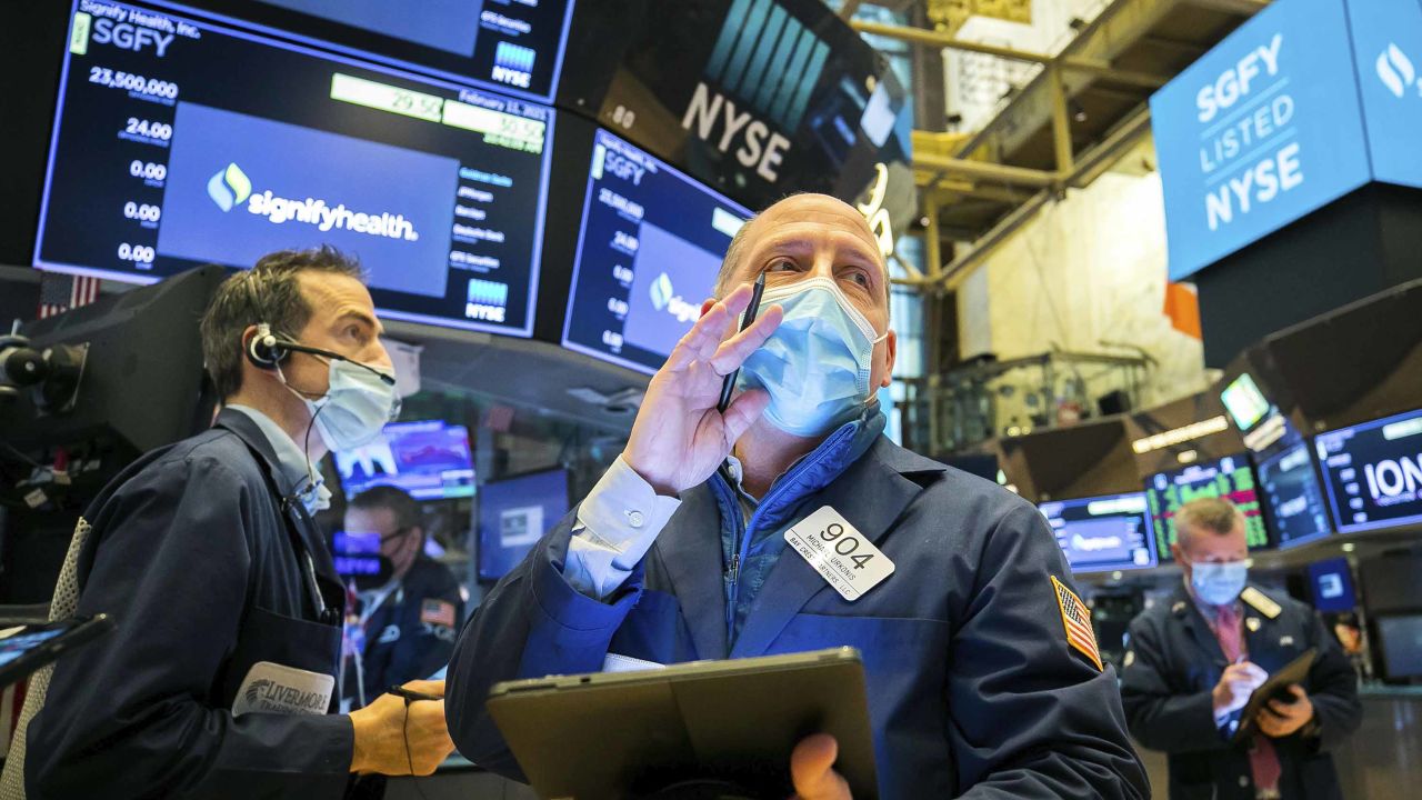 In this photo provided by the New York Stock Exchange, Michael Urkonis, center, works with fellow traders on the floor during the Signify Health IPO, Thursday, Feb. 11, 2021. Stocks edged higher on Wall Street in early trading Thursday as investors continued digesting solid corporate earnings reports and maintained confidence that a new round of government aid is on the horizon. (Courtney Crow/New York Stock Exchange via AP)