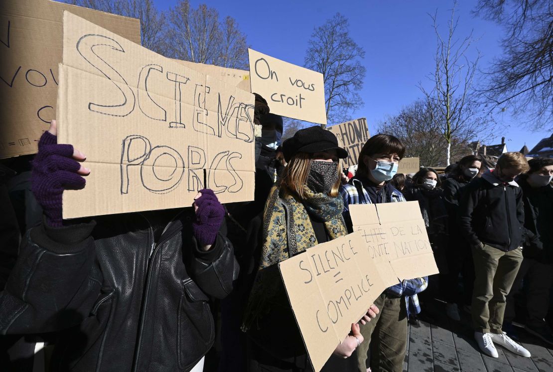 Students demonstrate in front of the Sciences Po university to denounce gender-based violence. Signs read "We believe you" and "Silence = accomplice."