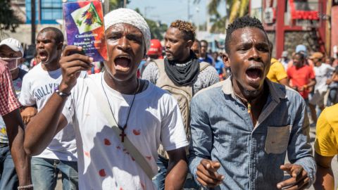 Demonstrators march in Port-au-Prince on February 10, 2021, to protest against the government of President Jovenel Moise. - Haitian police fired tear gas on hundreds of protesters who were marching against President Jovenel Moise and attacked journalists covering the demonstration, in the latest clashes to mark the country's political crisis. The protesters were accusing Moise of illegally extending his term. He says it lasts until February 2022 -- but the opposition argues it should have ended last weekend, in a standoff over disputed elections. (Photo by Valerie Baeriswyl / AFP) (Photo by VALERIE BAERISWYL/AFP via Getty Images)