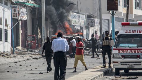 Security officers stand around the site of the car bomb attack in Mogadishu on February 13, 2021. 