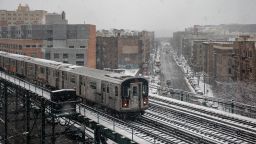 A subway train travels on the elevated track over snow-covered streets in the Bronx borough of New York City on on Sunday, February 7.