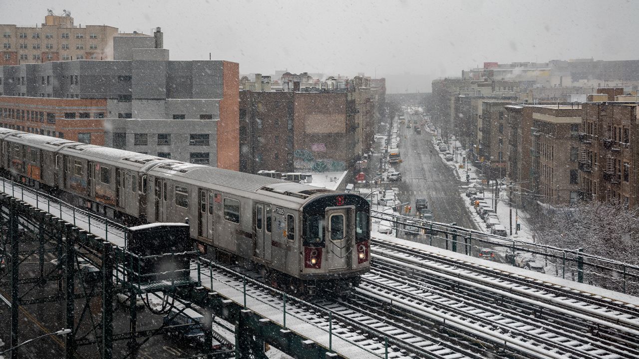 A subway train travels on the elevated track over snow-covered streets in the Bronx borough of New York City on Sunday, February 7.