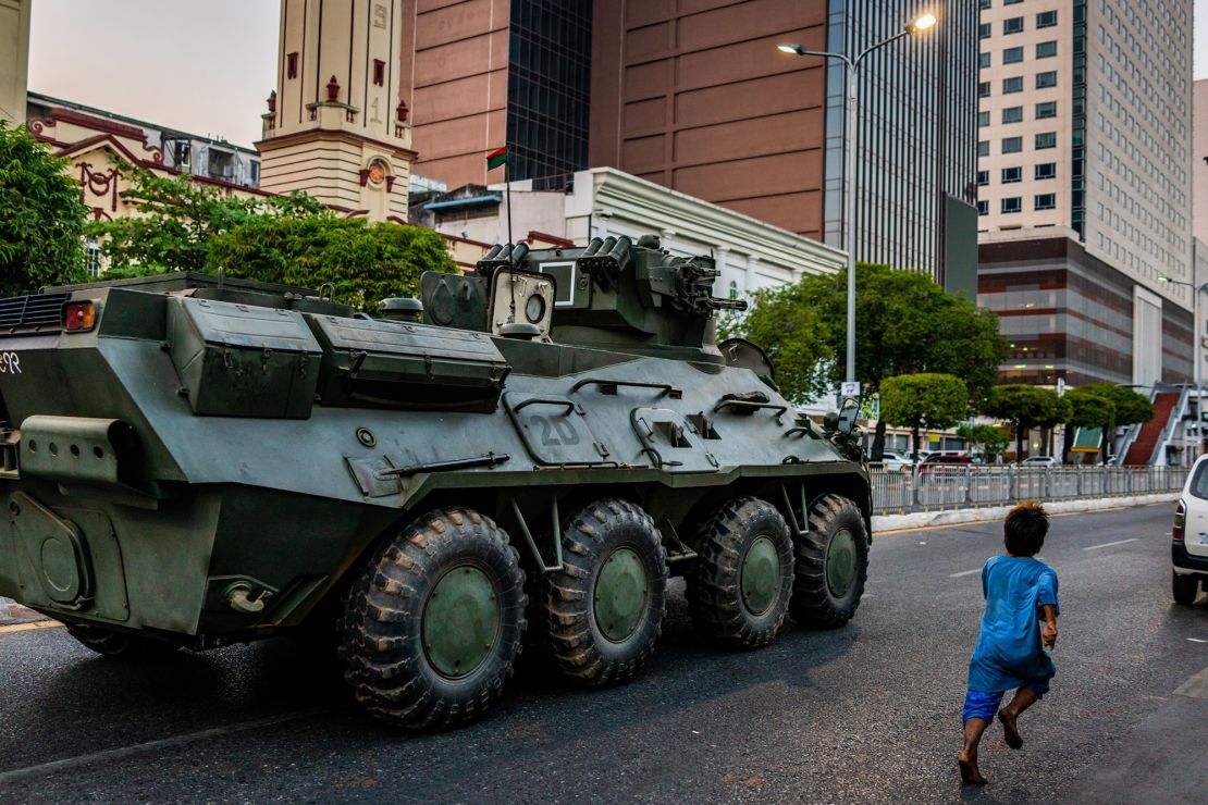 A child runs alongside a military armored vehicle moving along a street on February 14, 2021 in Yangon, Myanmar. 