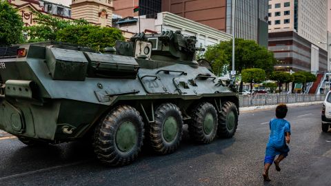 A child runs alongside a military armored vehicle moving along a street on February 14, 2021 in Yangon, Myanmar.
