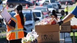 Volunteers load free groceries into cars for people experiencing food insecurity due to the coronavirus pandemic, December 1, 2020 in Los Angeles, California. - As of November 2020, food distribution by the Los Angeles Regional Food Bank has increased by 145% compared to the pre-pandemic levels. (Photo by Robyn Beck / AFP) (Photo by ROBYN BECK/AFP via Getty Images)