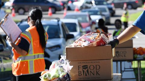 Volunteers load free groceries into cars for people experiencing food insecurity due to the coronavirus pandemic, December 1, 2020 in Los Angeles, California.