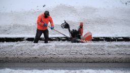 A worker clears snow from the sidewalk in Portland, Oregon on Saturday.