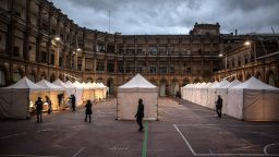 BARCELONA, SPAIN - FEBRUARY 14: Voters walk through a school courtyard inside a church compound that has been made into an outdoor polling station during regional Catalan elections on February 14, 2021 in Barcelona, Spain. In a survey, a third of those chosen by a draw to perform the civic duty of running polling locations on election day said they are worried about the risk of Covid-19 contagion. Spain has been amongst the worst-hit nations by the Coronavirus pandemic, and although the average number of infections has fallen the death rate remains high. (Photo by Finbarr O'Reilly/Getty Images)