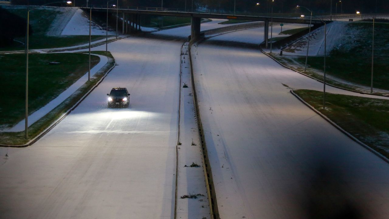 A police car slowly drives down Memorial Drive in Houston on Monday morning.