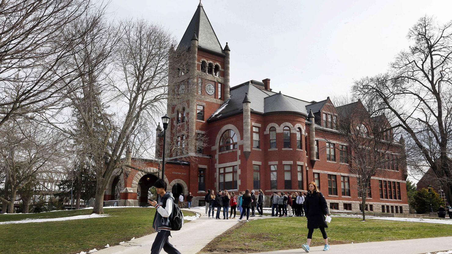 Students walk past the historic Thompson Hall at the University of New Hampshire in Durham in April 2016.