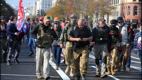 Rhodes, center in eye patch, marches with Oath Keepers through Washington, DC last November. Watkins is visible behind him to his right, wearing jeans and goggles on her ballistic helmet. 