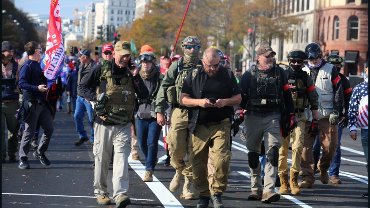 Stewart Rhodes, center in eye patch, marches with Oath Keepers through Washington, DC in Nov. 2020. Jessica Watkins is visible behind him to his right, wearing jeans and goggles on her ballistic helmet. Both have pleaded not guilty to seditious conspiracy charges.