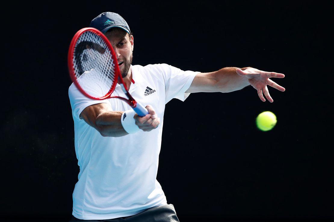 Karatsev plays a forehand against Dimitrov.