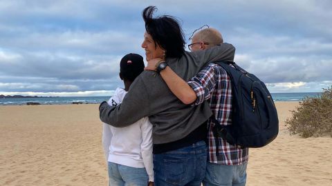 Abou, left, from Ivory Coast, is pictured with his foster parents Deli Delgado and Victor Afonso at Corralejo beach, an area where many boats land when they arrive in the Canary Islands from West Africa.