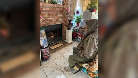 Barbara Martinez's father sits in front of the fireplace at her home in a Houston suburb.