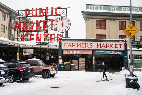 Harrison Walsh skis by Seattle's Pike Place Market on Saturday.