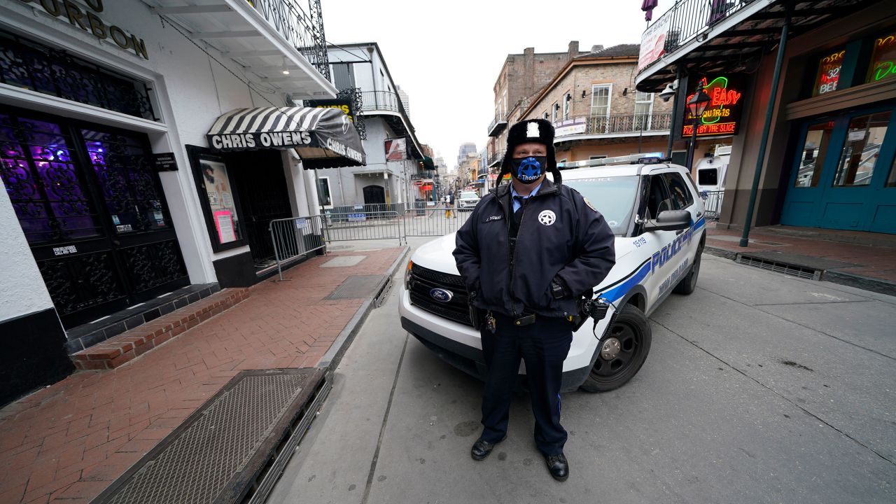 A police officer stands guard on a nearly deserted Bourbon Street in the French Quarter on Tuesday.