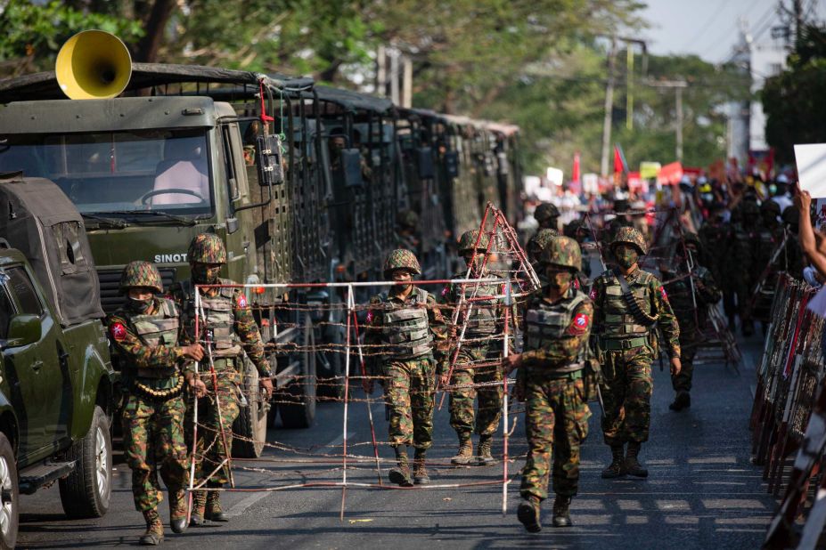 Soldiers carry barricades in Yangon on February 15.