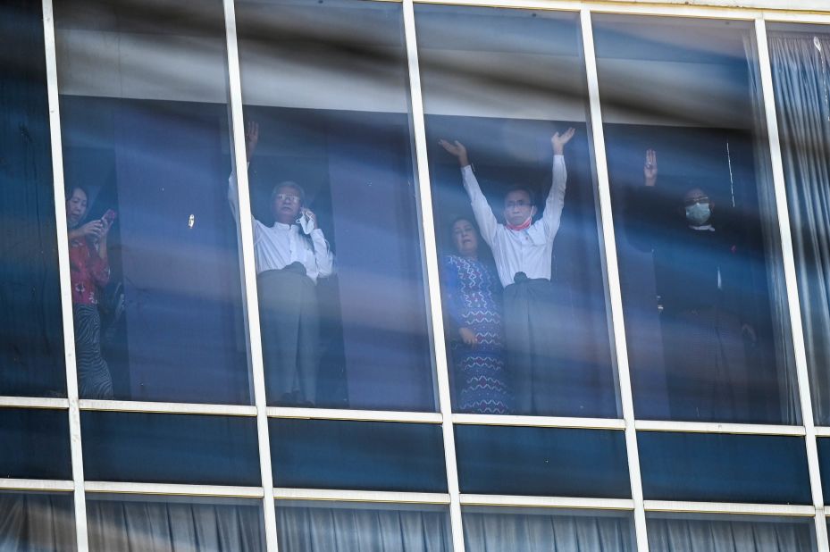 Elected members of Parliament wave to protesters in Yangon as police surround the headquarters of Suu Kyi's political party, the National League for Democracy, on February 15.