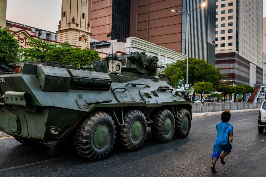 A child runs alongside an armored vehicle in Yangon on February 14.