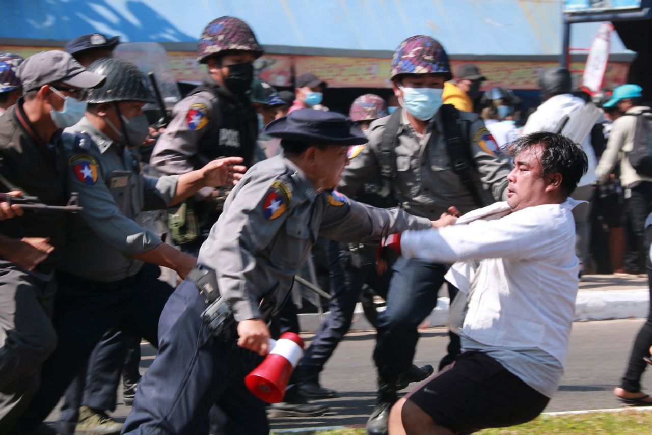 Police detain a protester during a demonstration in Mawlamyine on February 12.