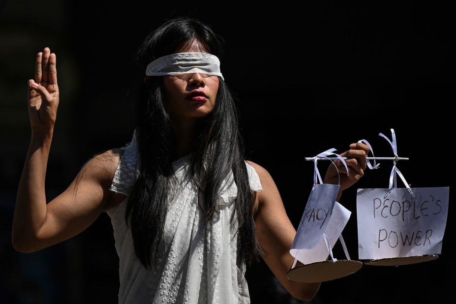 A protester dressed as Lady Justice makes a three-finger salute as she takes part in a demonstration in Yangon on February 11.