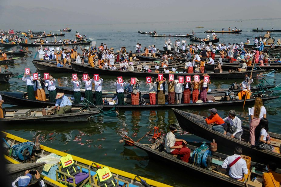 People hold up letters that spell "get out dictators" during a demonstration at Inle Lake on February 11.