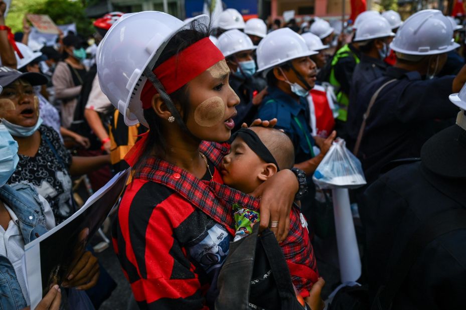 A protester carries a child during a march in Yangon on February 10.