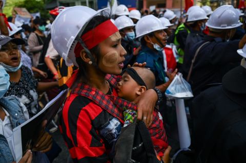 A protester carries a child during a march in Yangon on February 10.