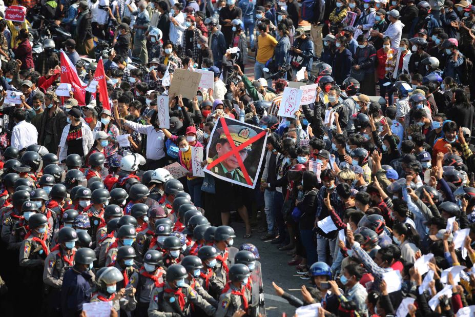 Protesters flash three-fingered salutes as they face rows of riot police in Naypyidaw on February 8.