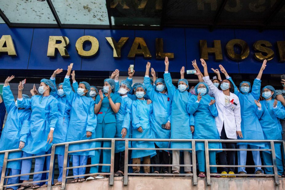 Hospital workers show three-finger salutes during a demonstration in Yangon on February 7.