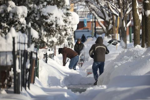 Residents clear snow from a sidewalk in Chicago on Tuesday.