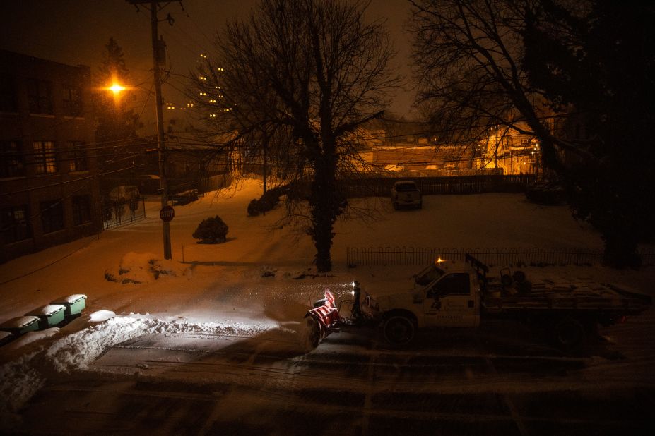 A snow plow clears a parking lot in Columbus, Ohio, early on Tuesday.