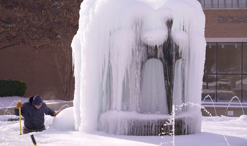 City worker Kaleb Love works to clear ice from a water fountain in Richardson, Texas, on Tuesday.